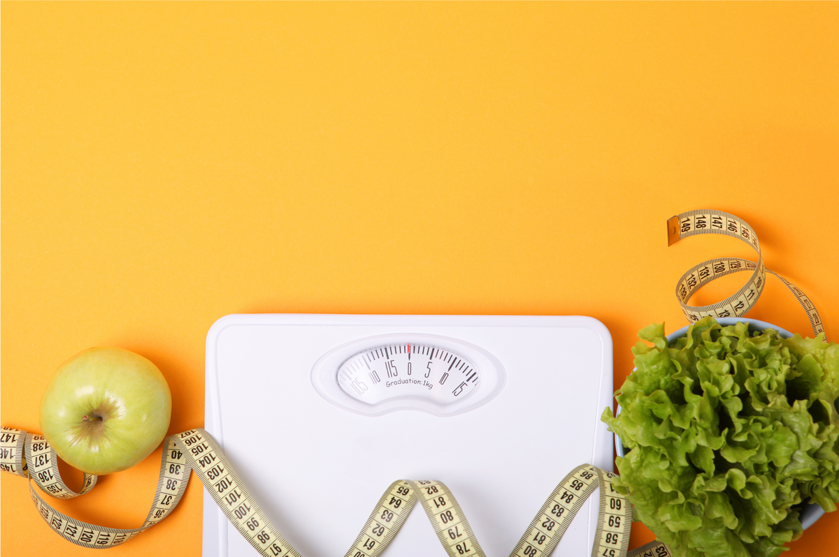 Article cover for "Spring Into a Healthier You: Support Your Weight Loss Goals With proBLENopathy" with an orange background. A scale, a tape measure, a head of lettuce, and an apple are on the bottom.